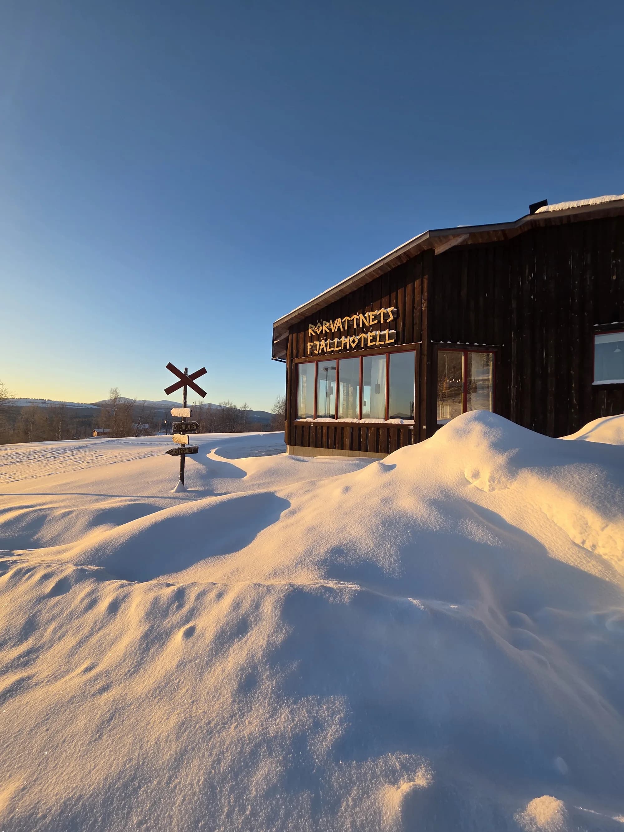 Hotellet i vinterskrud med snötäckta fjäll